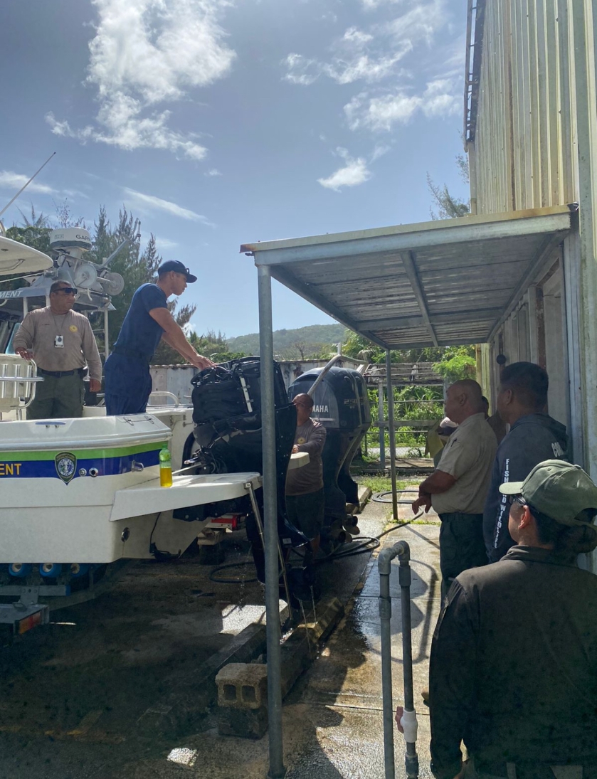Staff looking at engine of boat