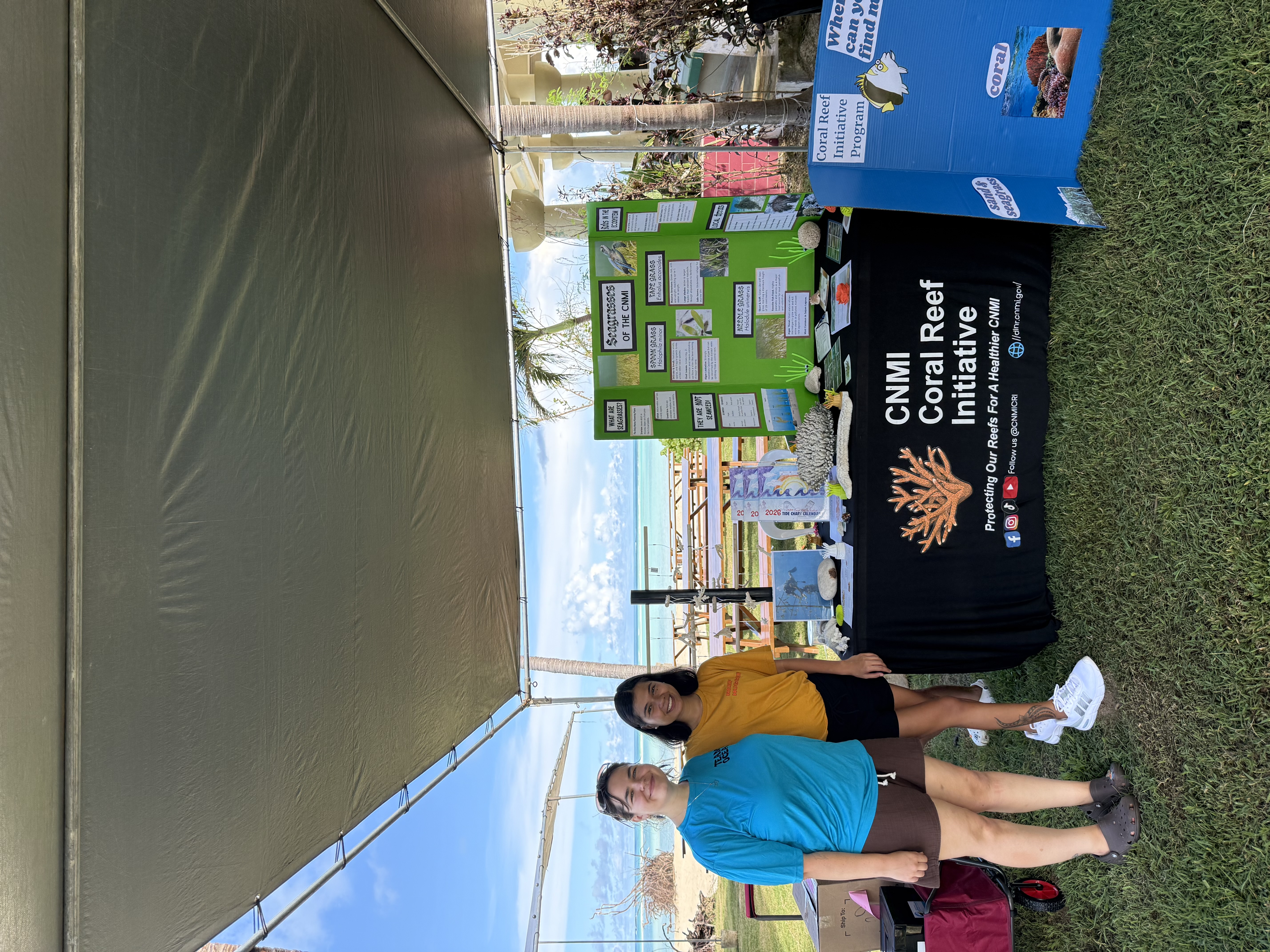 coral reef initiative employees standing next to table at outreach event